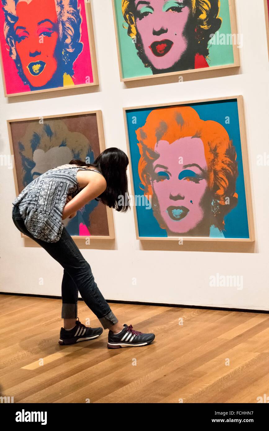 Young Woman Bending Over to Closely Inspect one of Andy Warhol´s Marilyn Monroe Paintings at the Museum of Modern Art, New York Stock Photo