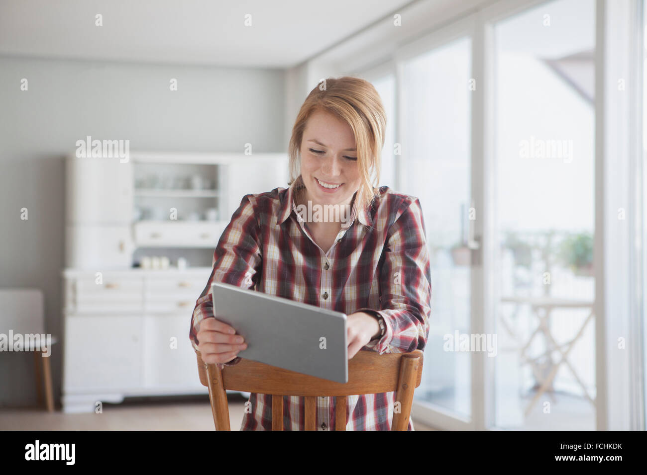 Portrait of smiling young woman using her digital tablet at home Stock ...