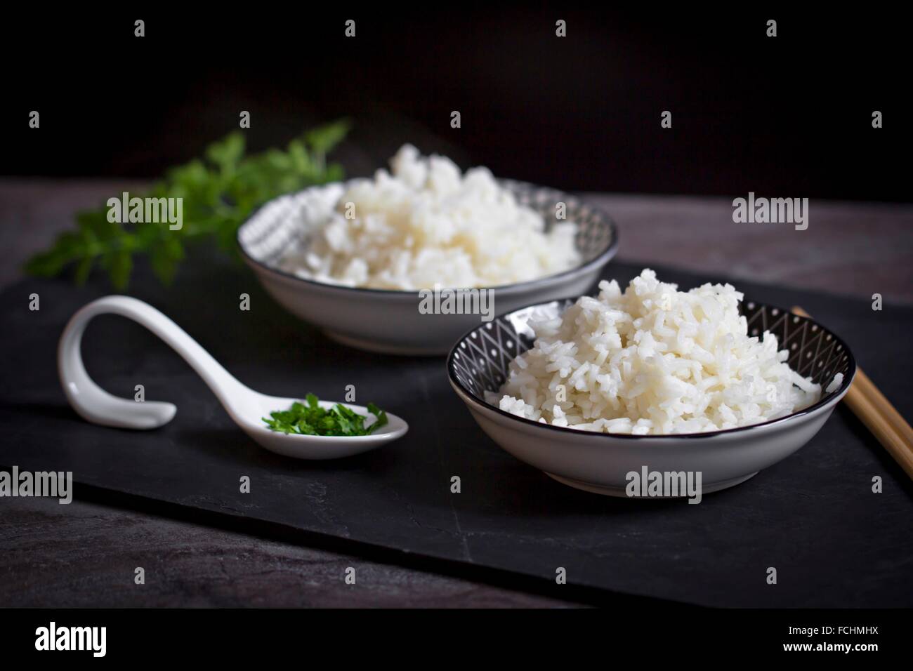 Parli Rice Two bowls of long grain rice parsley Stock Photo - Alamy