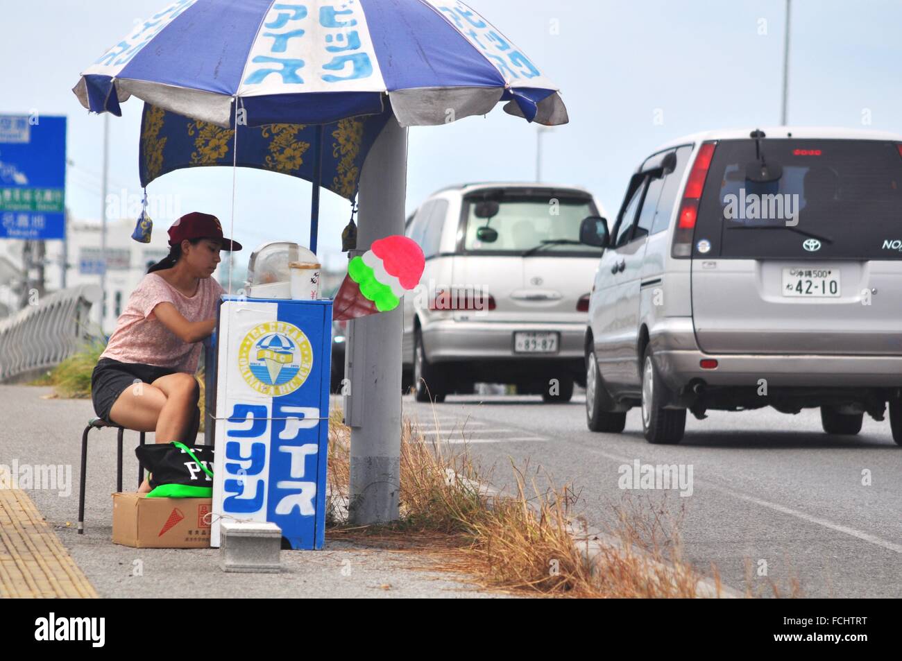 Tomishiro, Okinawa, Japan a woman selling icecreams to drivers along