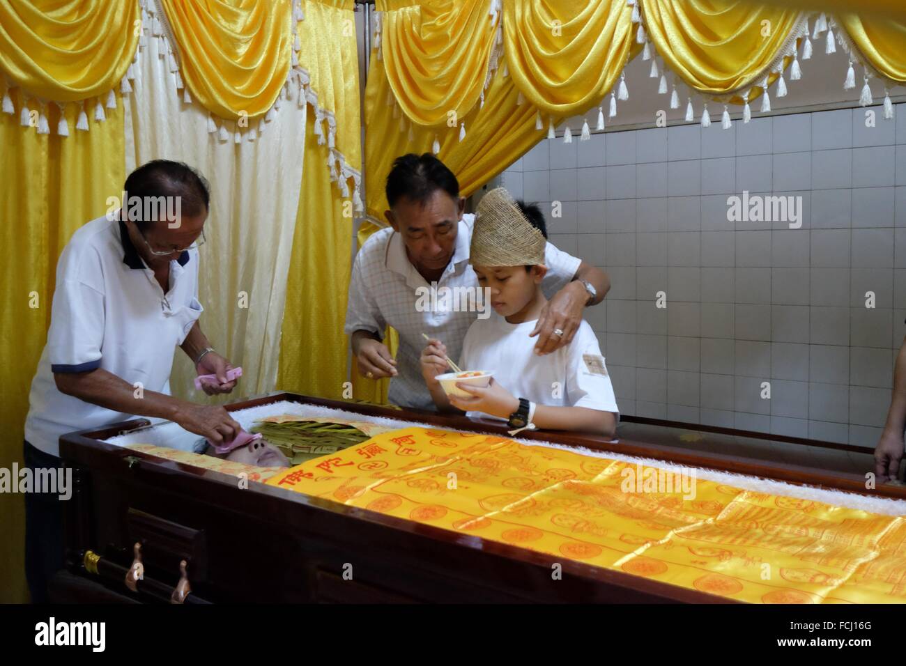 The eldest son feeds the late dad with rice. Sarawakian chinese funeral ceremony. Malaysia Stock