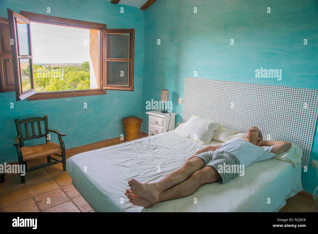 Man lying on bed in a rural hotel. Segovia, Spain Stock Photo Alamy