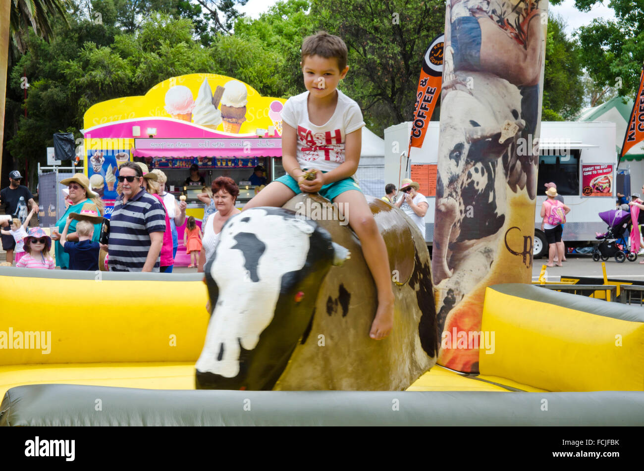 Young boy riding a mechanical bull Stock Photo