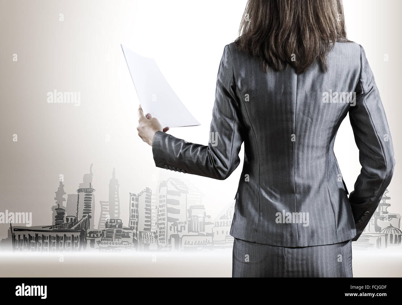 Rear view of businesswoman with papers in hand Stock Photo - Alamy
