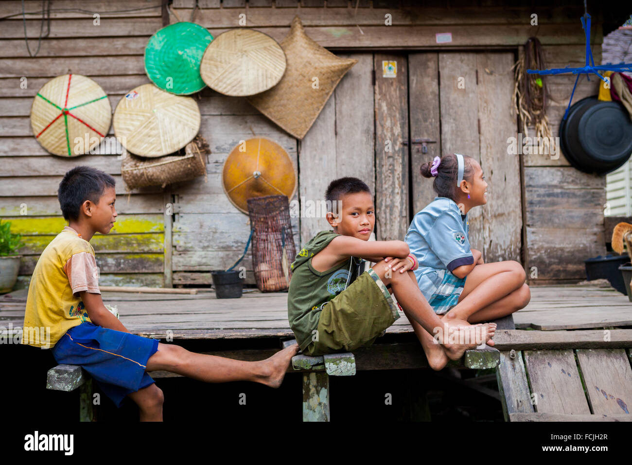 Portrait of a group of children in front of a wooden house in Nanga Raun village, Kalis, Kapuas Hulu, West Kalimantan, Indonesia. Stock Photo