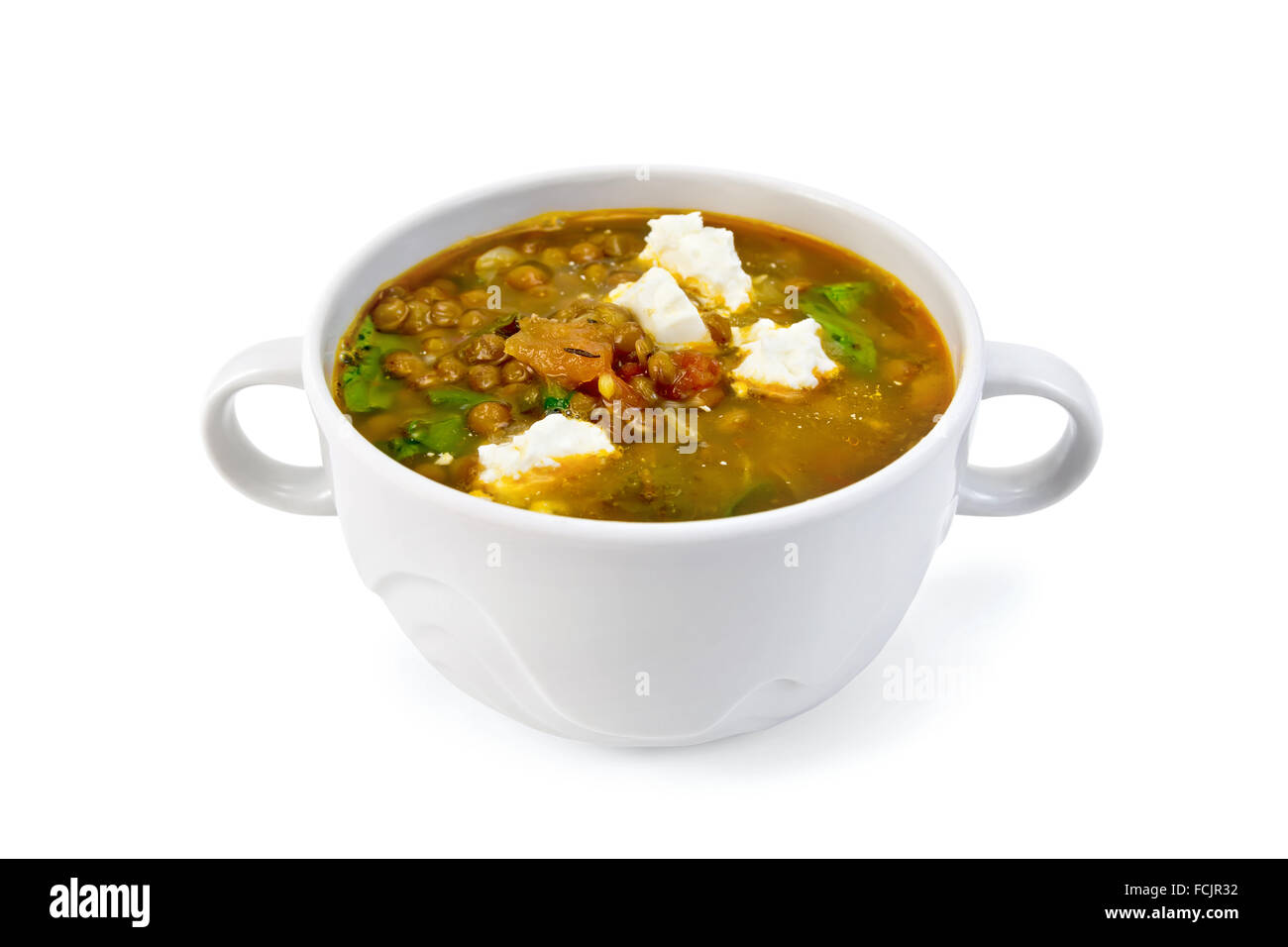 Lentil soup with spinach, tomatoes and feta cheese in a bowl isolated on white background Stock Photo