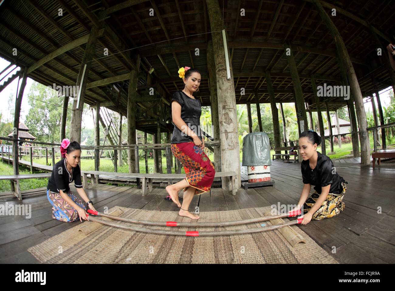 Dancer in traditional costume peforming bamboo dance in the Sarawak