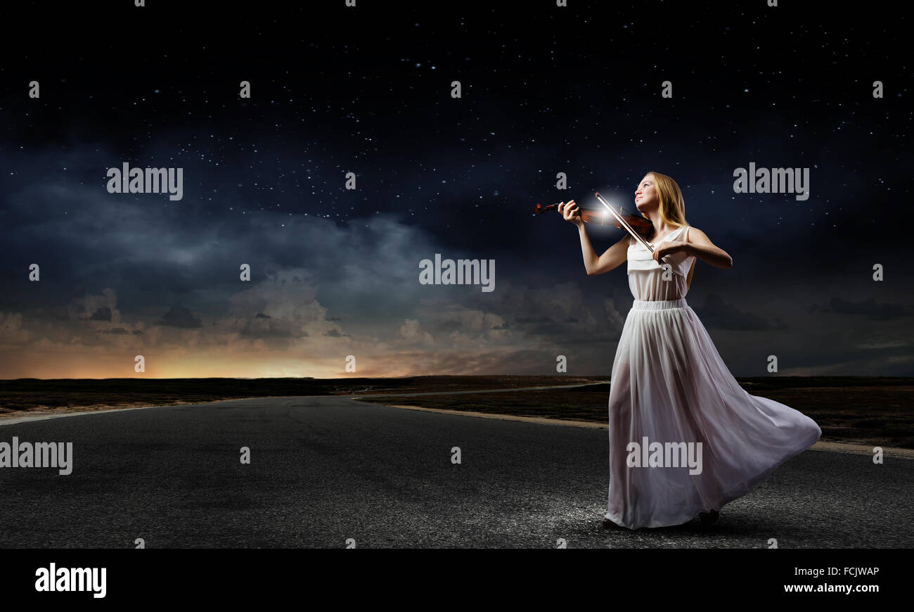 Young woman in white dress playing violin Stock Photo - Alamy