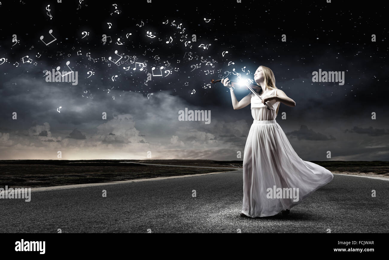 Young woman in white dress playing violin Stock Photo - Alamy