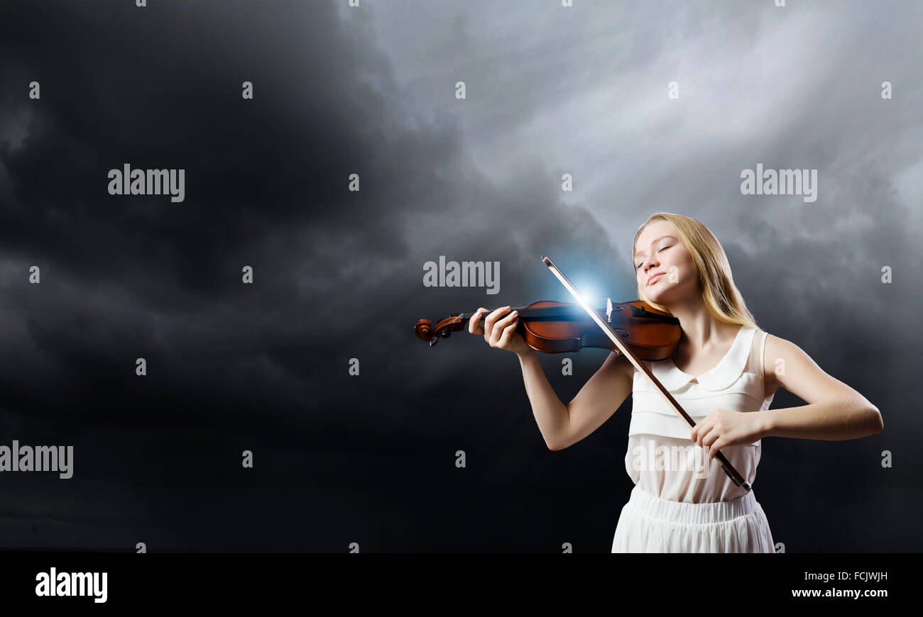 Young woman in white dress playing violin Stock Photo - Alamy