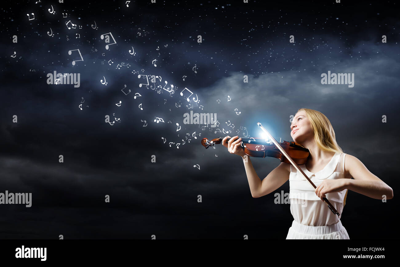 Young woman in white dress playing violin Stock Photo - Alamy
