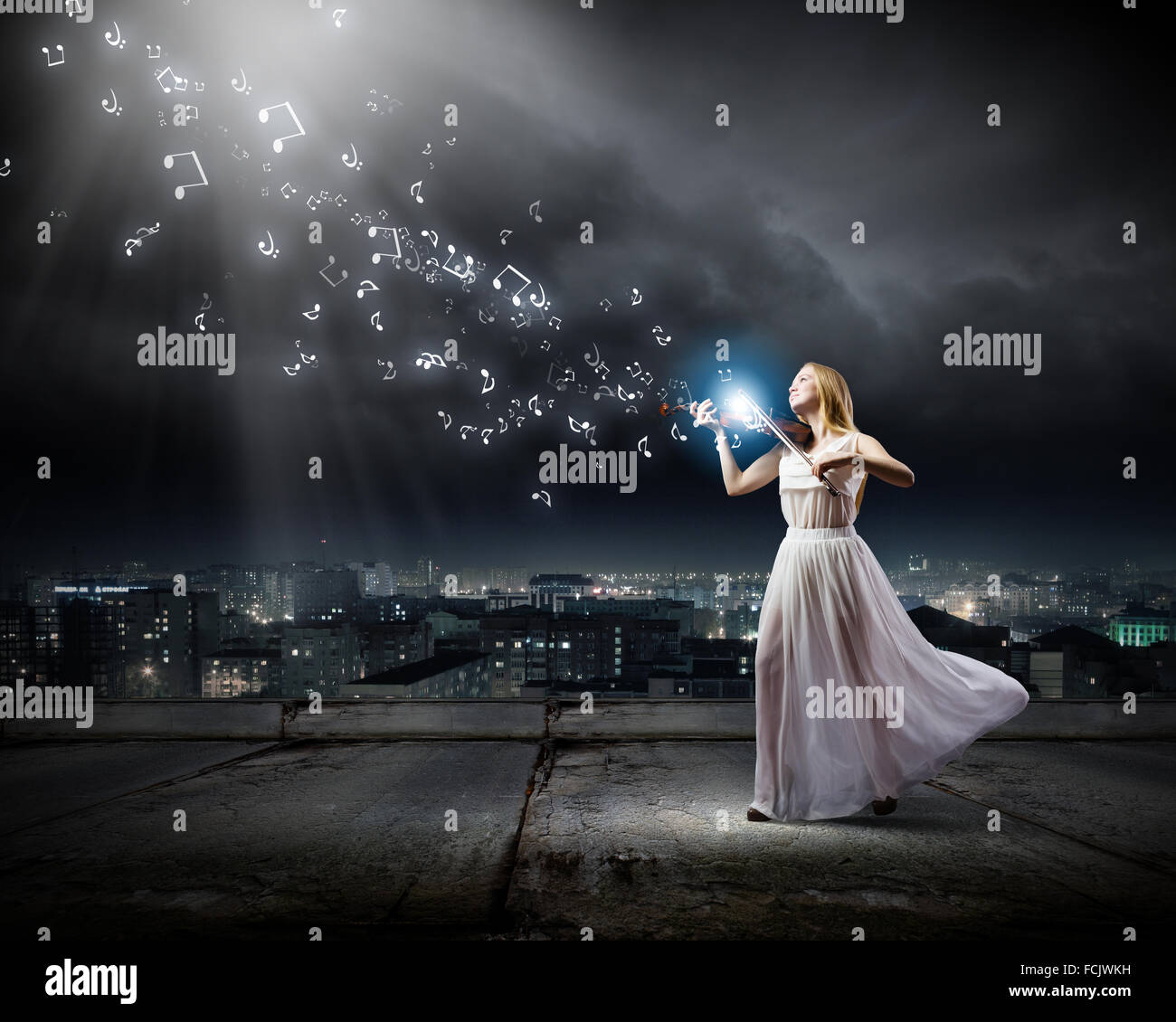 Young woman in white dress playing violin Stock Photo - Alamy
