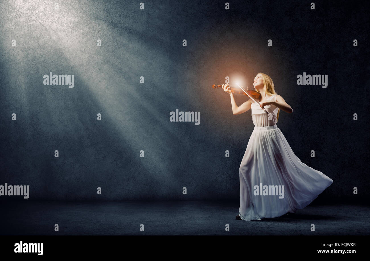 Young woman in white dress playing violin Stock Photo - Alamy