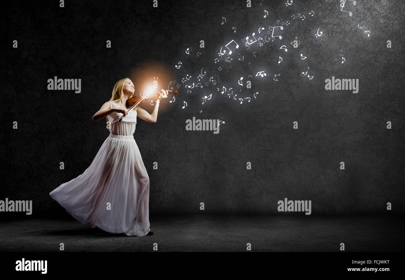 Young woman in white dress playing violin Stock Photo - Alamy