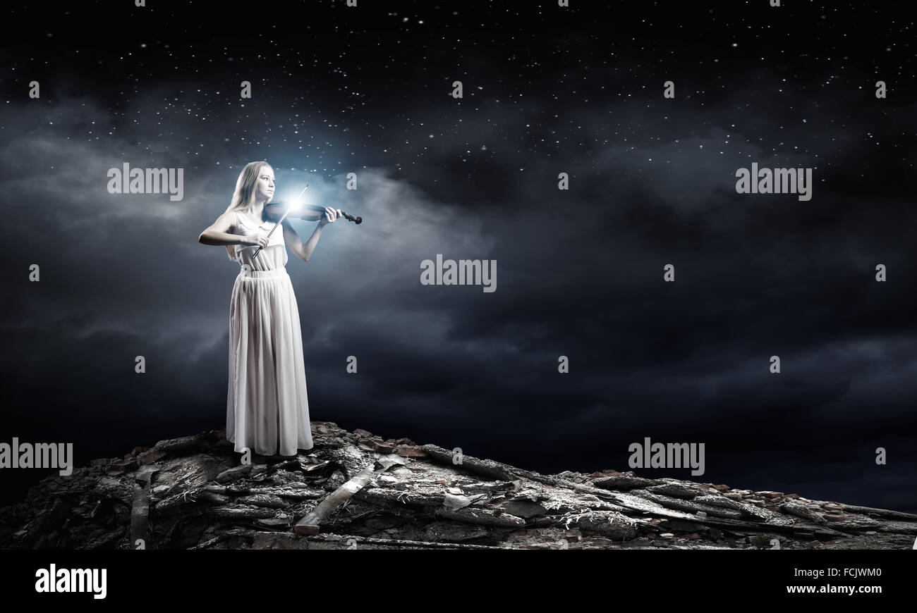 Young woman in white dress playing violin Stock Photo - Alamy