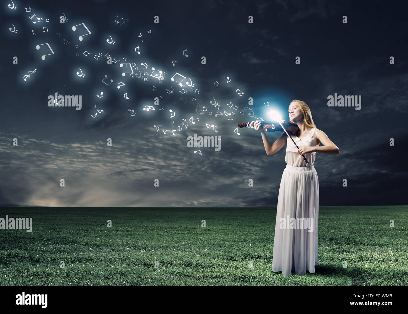 Young woman in white dress playing violin Stock Photo - Alamy