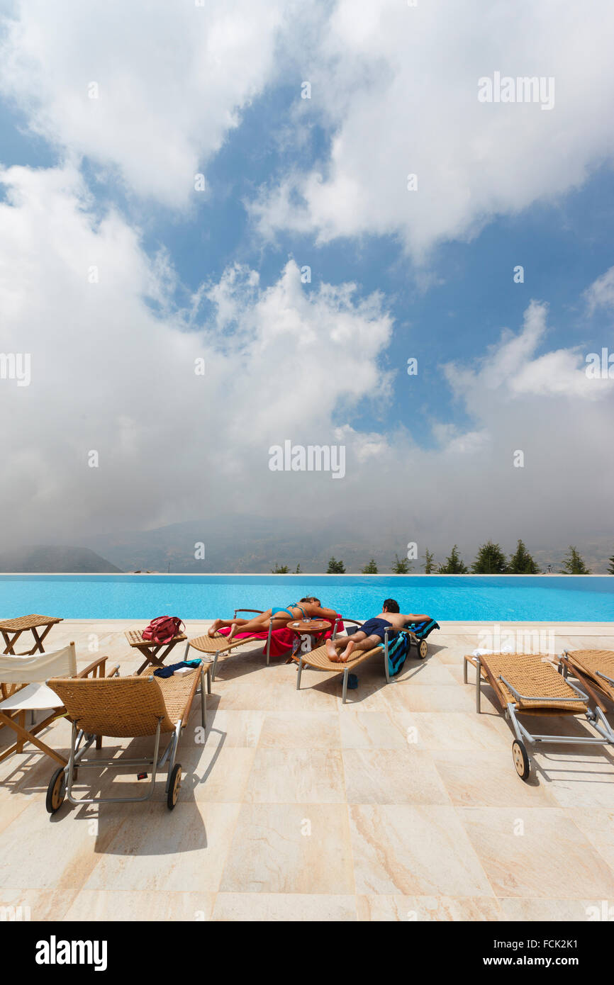 Couple lying in the sun at hotel swimming pool in Faraya, Lebanon Stock