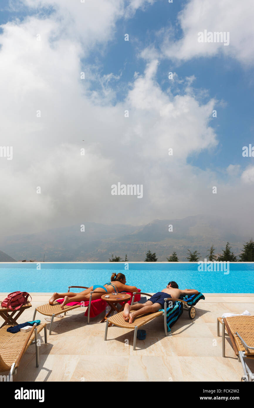 Couple lying in the sun at hotel swimming pool in Faraya, Lebanon Stock