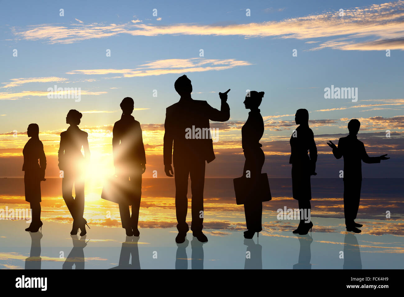 Silhouettes of business people against sunset landscape Stock Photo - Alamy
