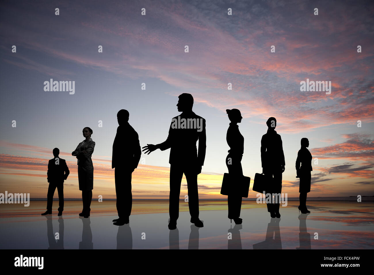 Silhouettes of business people against sunset landscape Stock Photo - Alamy