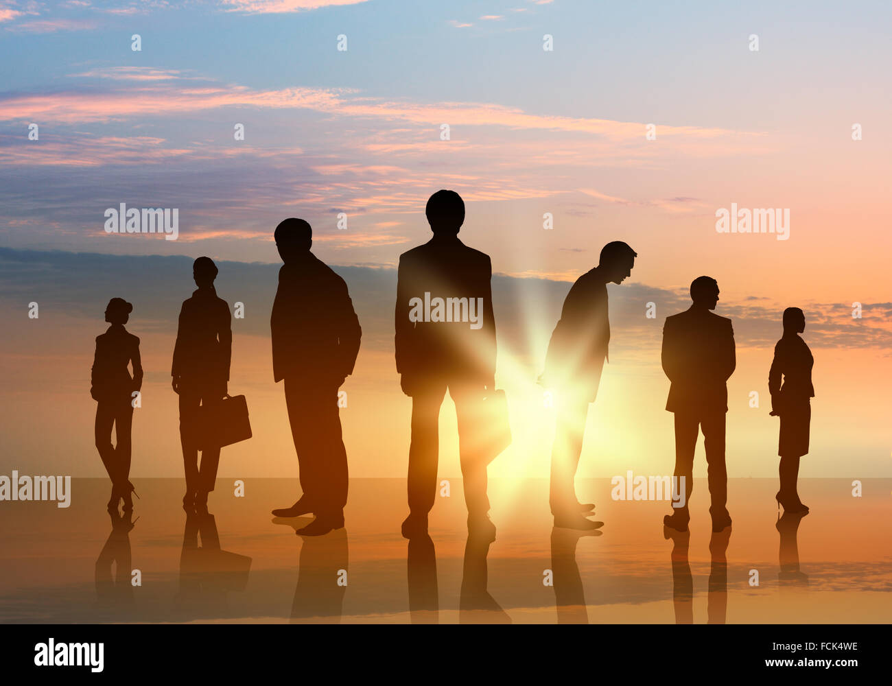 Silhouettes of business people against sunset landscape Stock Photo - Alamy