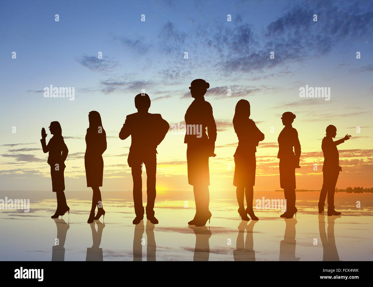 Silhouettes of business people against sunset landscape Stock Photo - Alamy