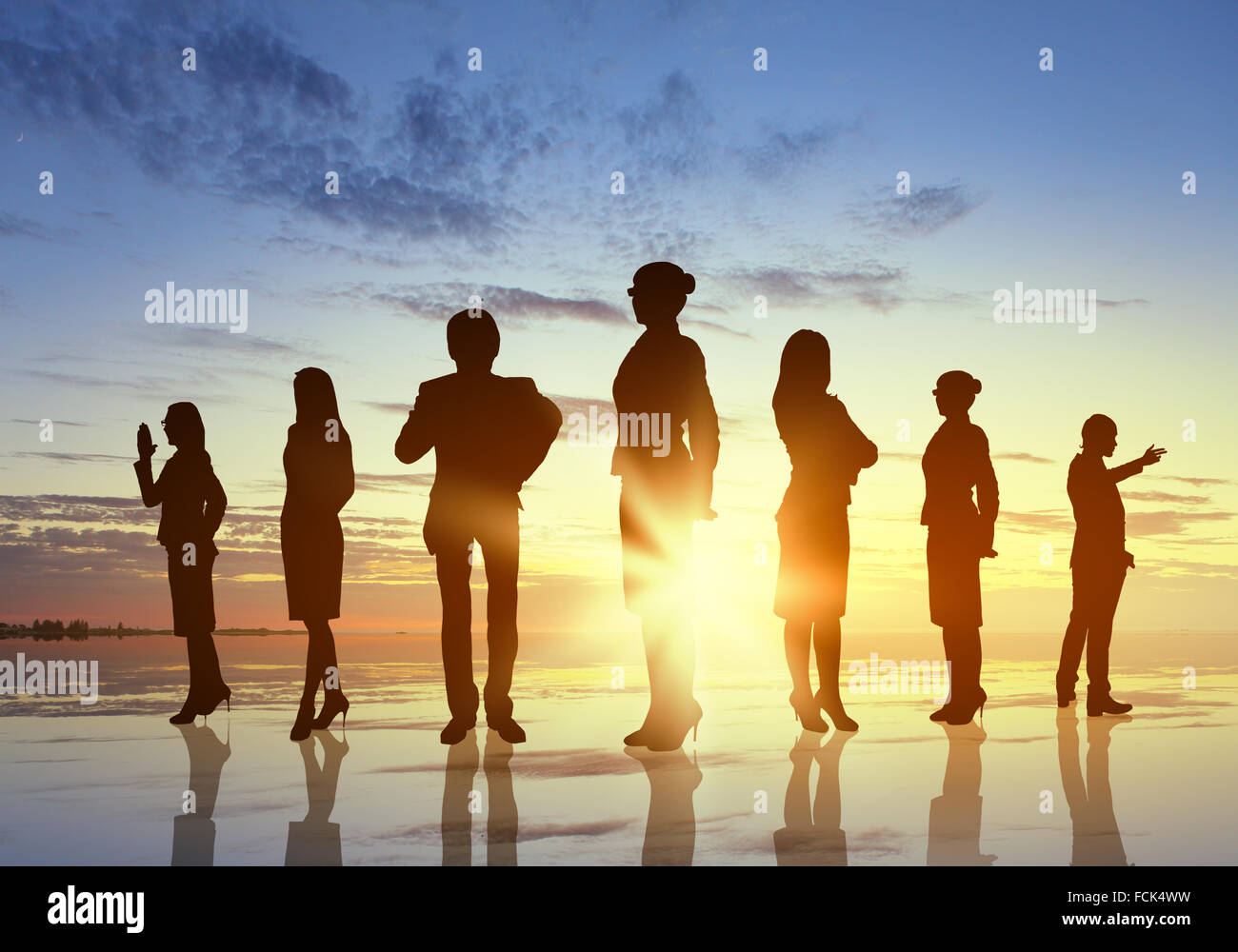 Silhouettes of business people against sunset landscape Stock Photo - Alamy