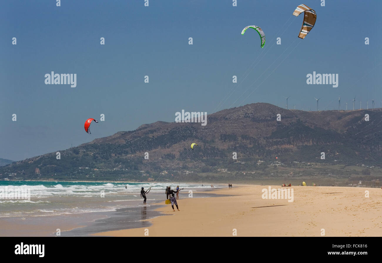 Sportsmen kite surfers on clean beach in summer day, Tarifa, Spain Stock Photo