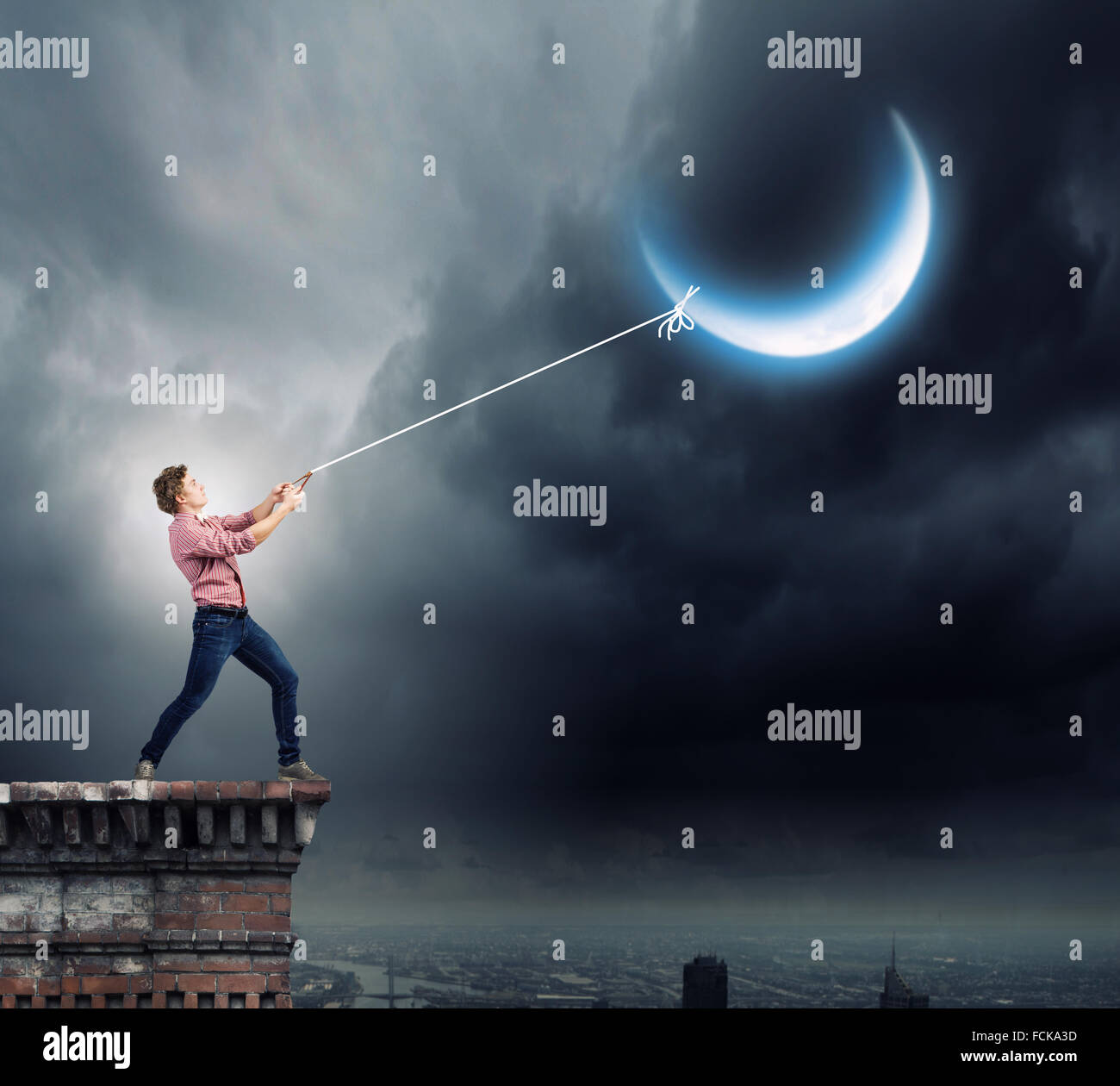 Young man in casual catching moon with rope Stock Photo - Alamy