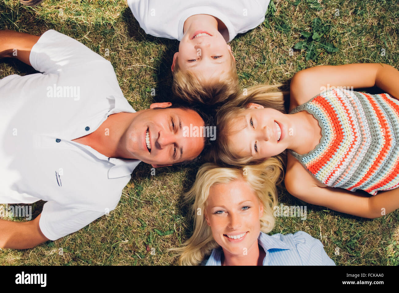 Happy family lying on a meadow Stock Photo - Alamy