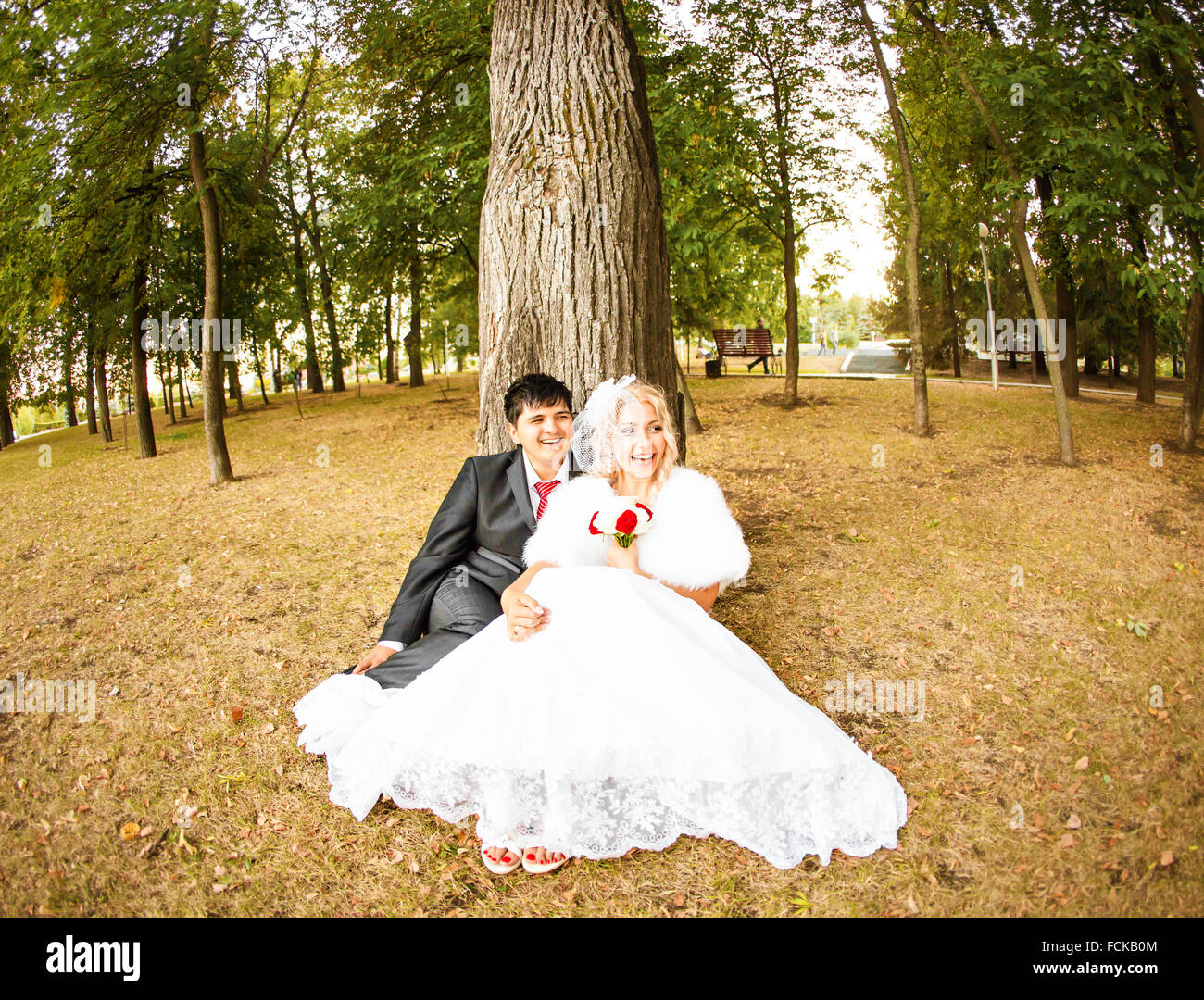wedding couple hugging, the bride holding a bouquet of flowers in her ...
