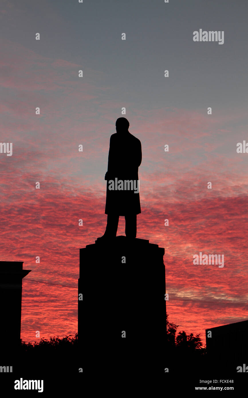 Statue of Vladimir Lenin in Veliky Novgorod silhouetted against a red cloudy evening sky, Novgorod Oblast, Russia. Stock Photo