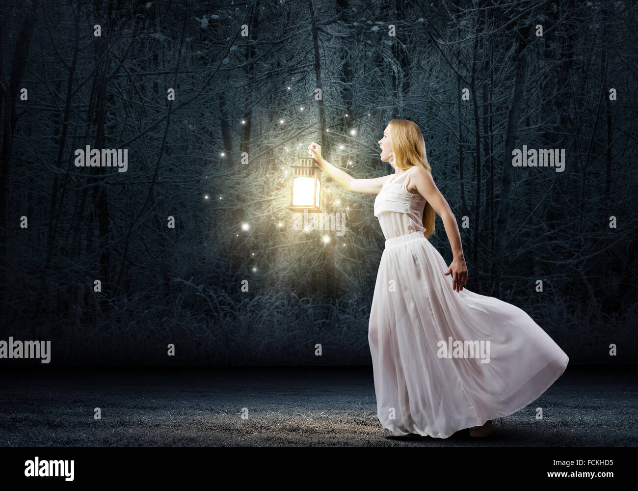 Young woman with lantern walking in dark forest Stock Photo - Alamy