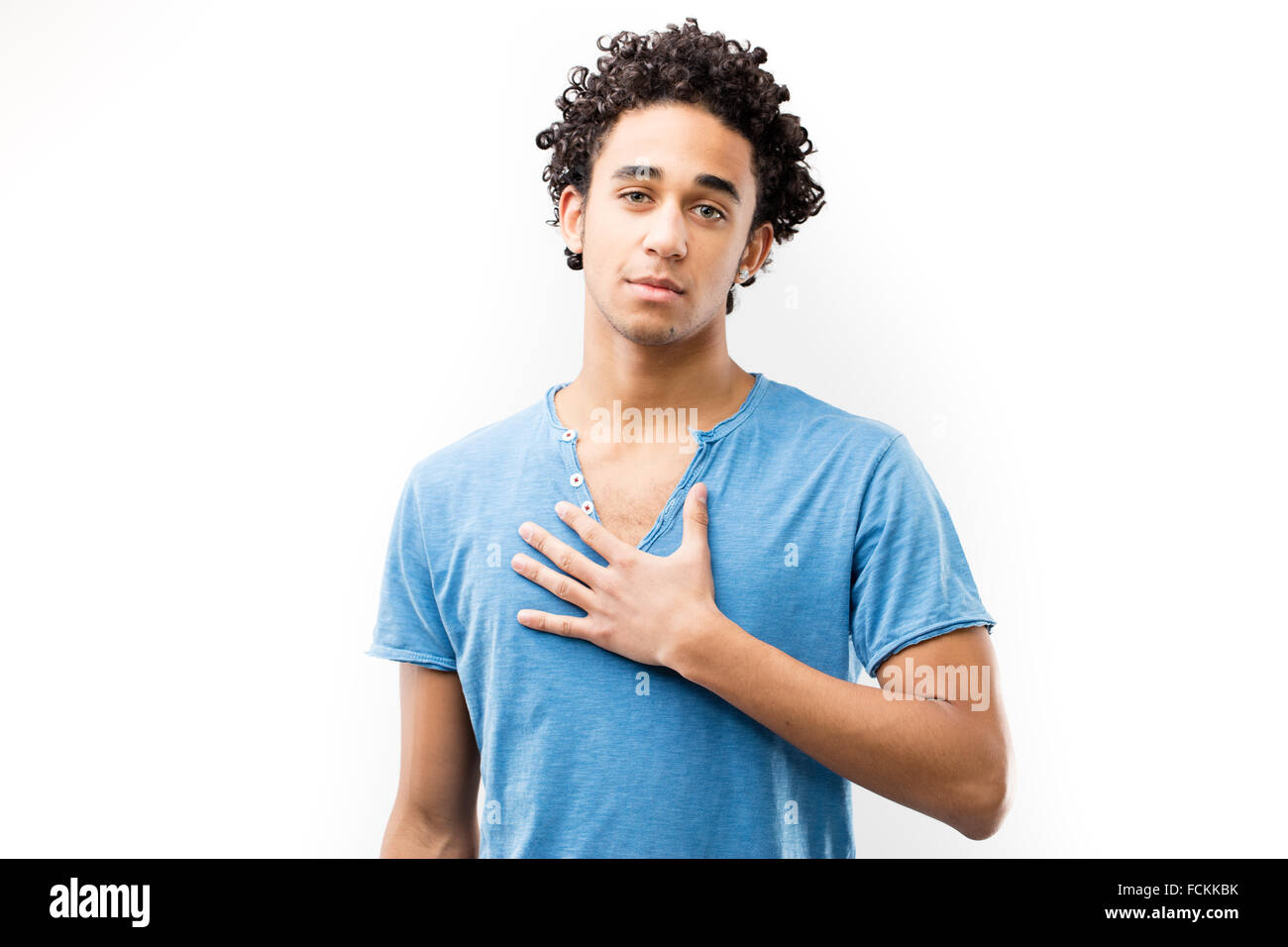 young fascinating man with his hand on his chest meaning he's dedicated and his deep feelings