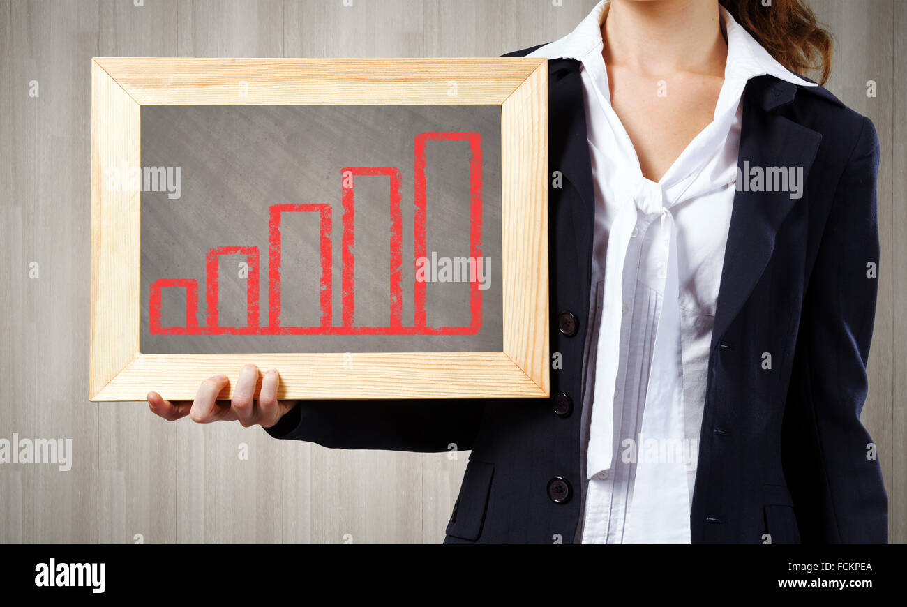 Young woman holding frame with increasing graph Stock Photo - Alamy