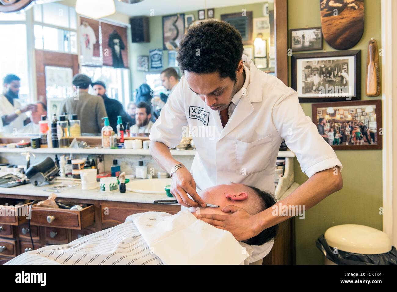 Rotterdam, Netherlands. Barber store Schorem. Male customer lying back
