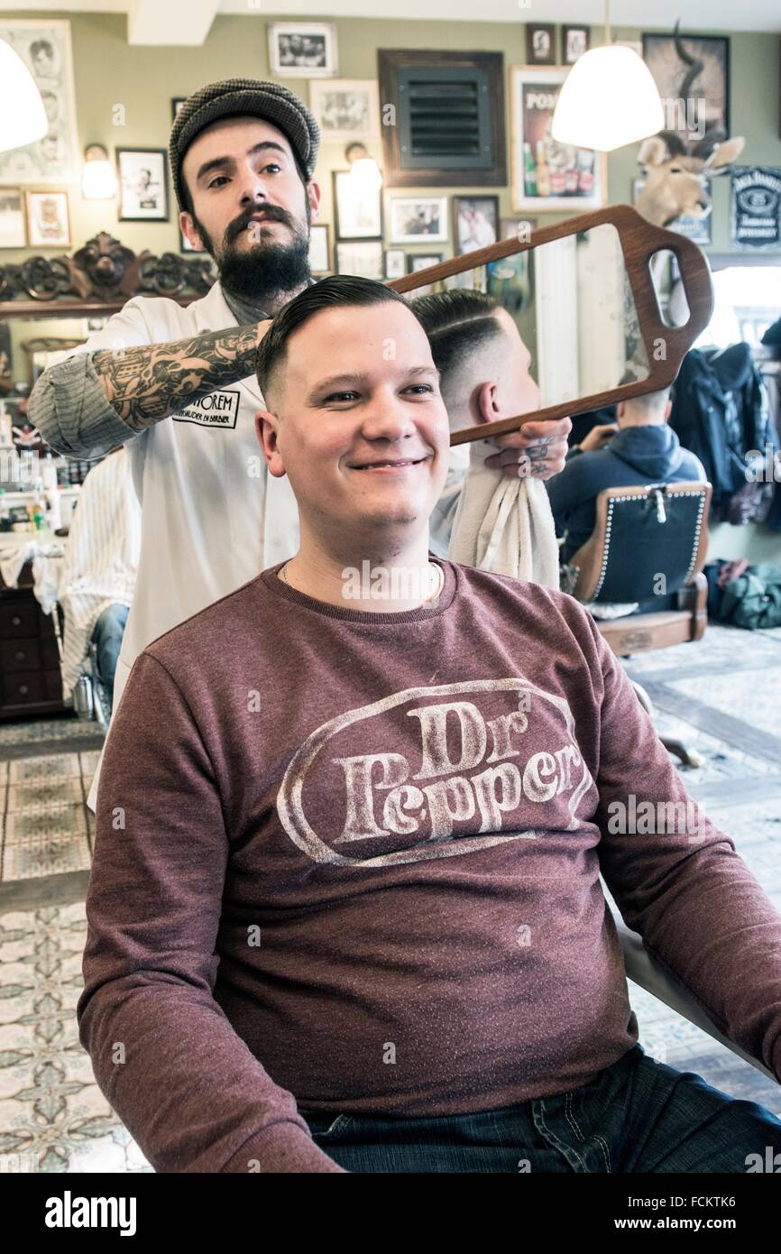 Rotterdam, Netherlands. Barber store Schorem. Barber showing his customer  the results of his haircut by using an hand held Stock Photo - Alamy