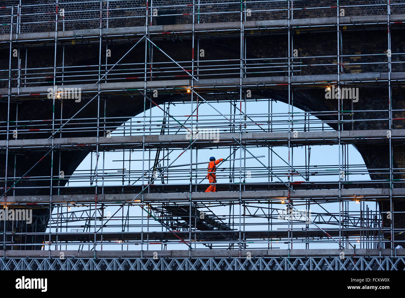 Railway workers on scaffolding carrying out maintainance work on the ...