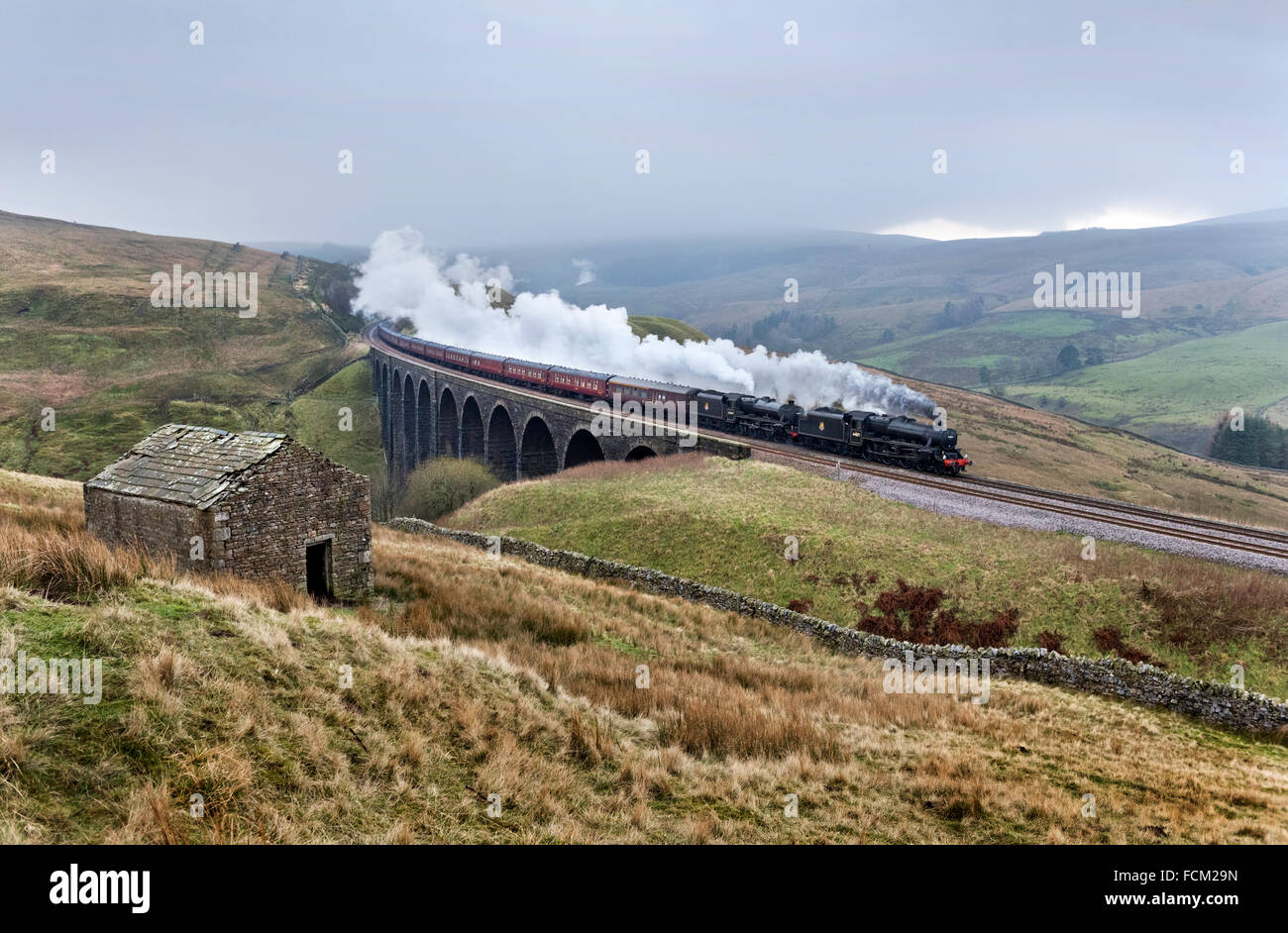 Dentdale, Yorkshire Dales, UK. 23rd January, 2016. Double-headed steam excursion crosses Arten Gill Viaduct, near Dent in the Yorkshire Dales National Part. The first steam excursion of the year over the Settle to Carlisle railway line is hauled by two Black Five locomotives. Double-headed trains are seldom seen over this line. Stock Photo