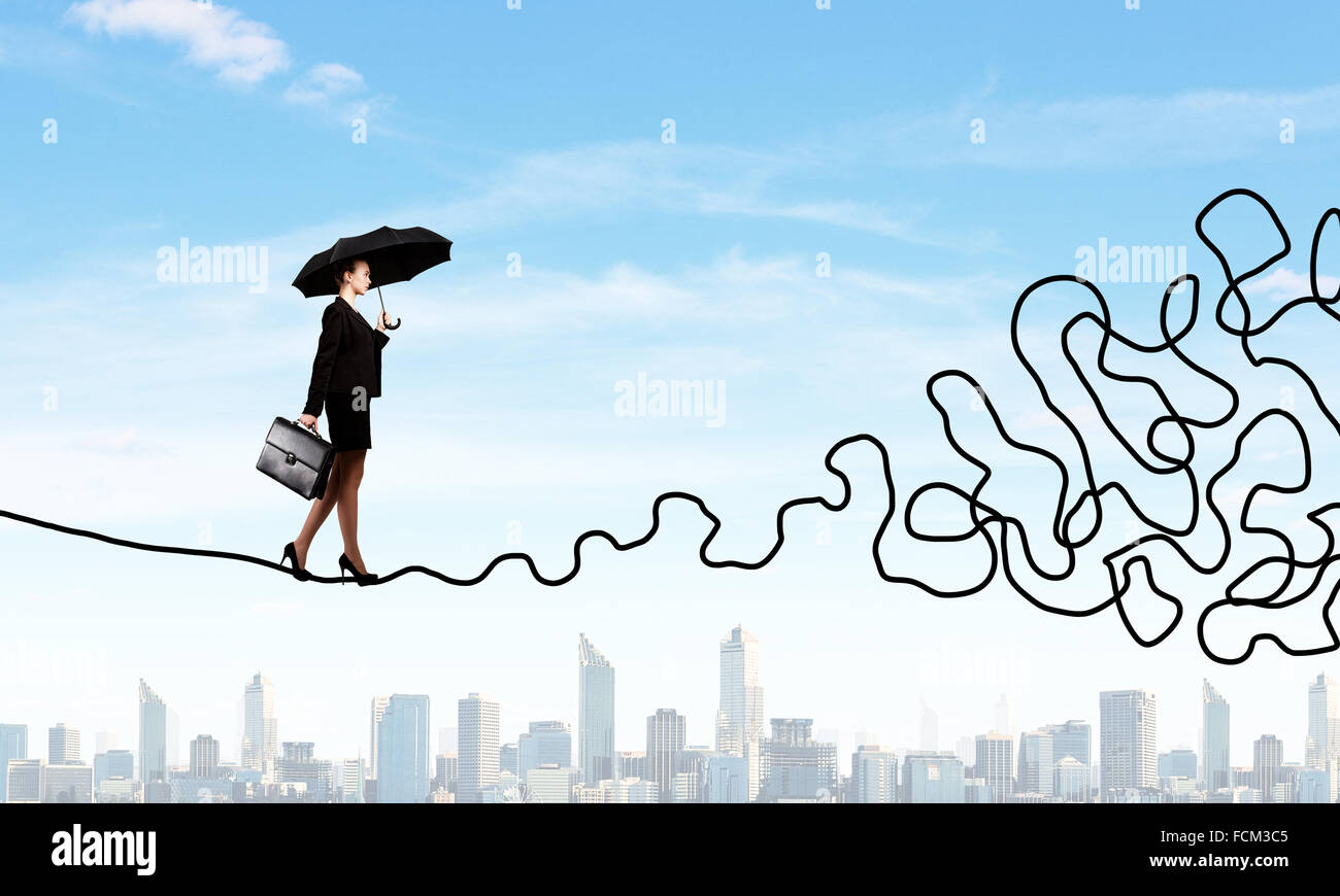 Young businesswoman walking on twisted rope high in sky Stock Photo - Alamy