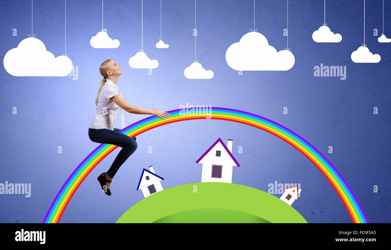 Young pretty happy girl sitting on rainbow Stock Photo