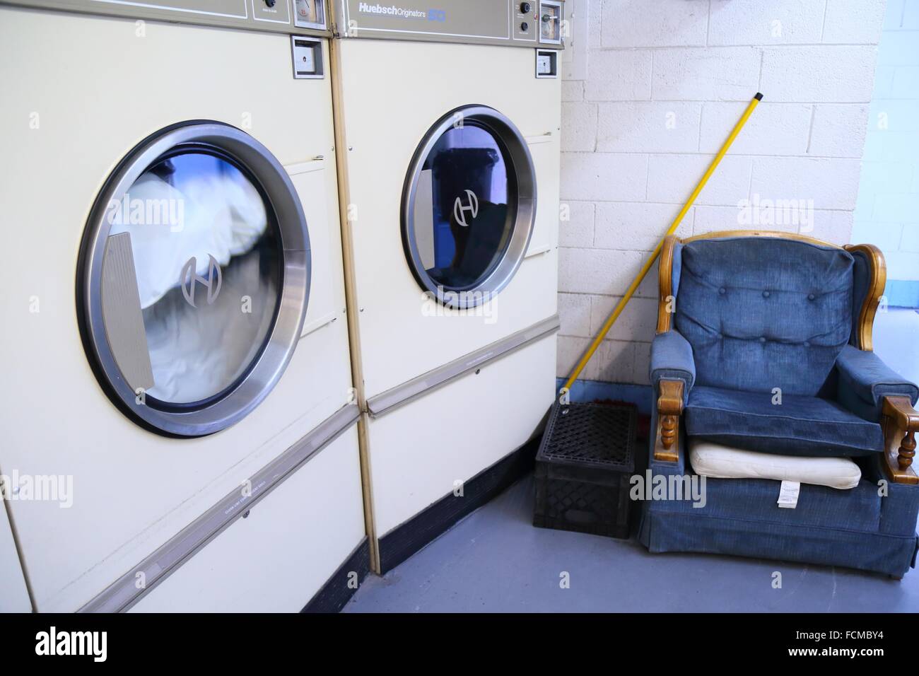Dryers at laundromat and couch Stock Photo Alamy