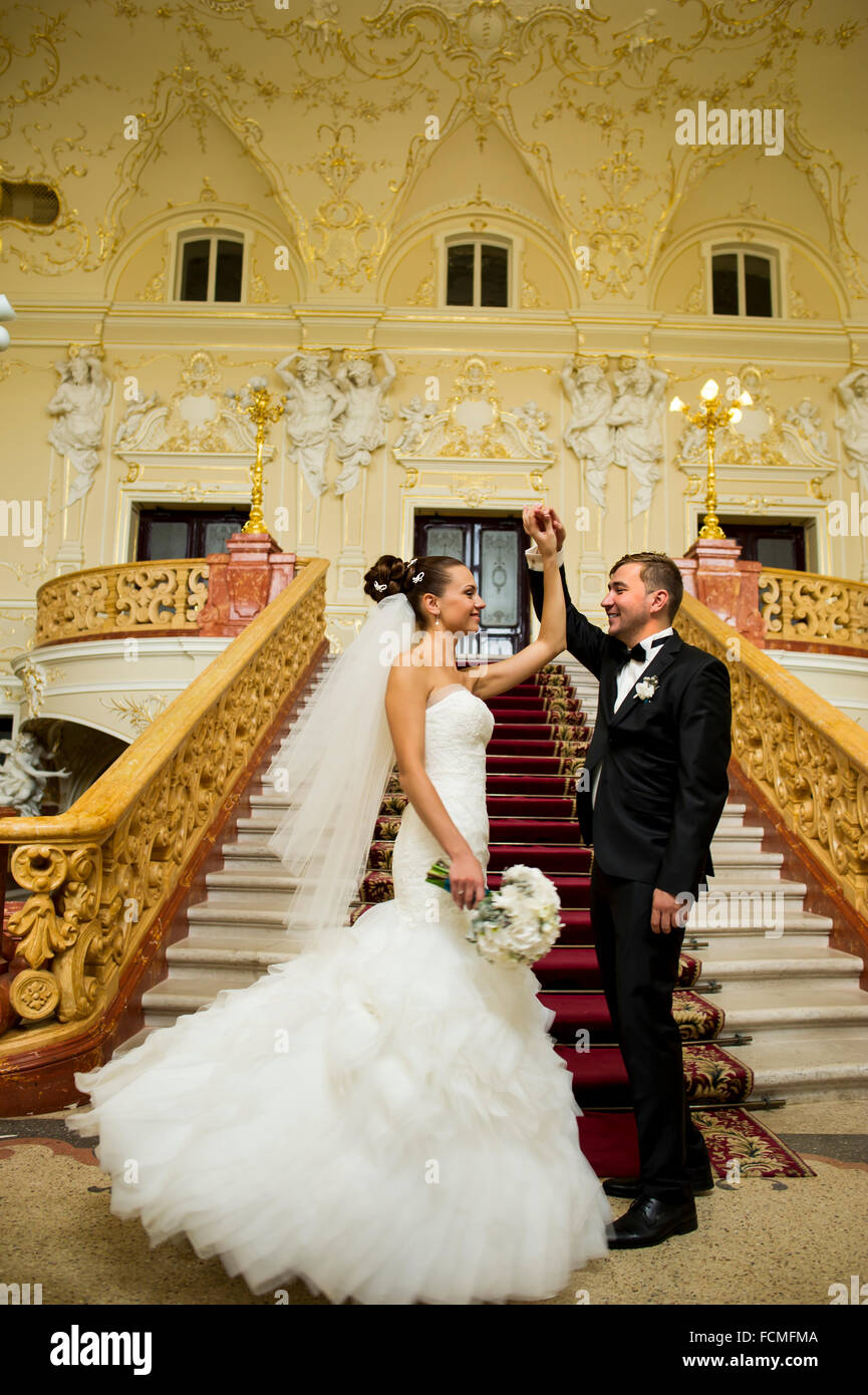Newlyweds are holding their hands up in palace Stock Photo - Alamy