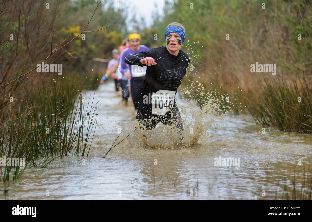 Aldershot, Hants, UK. 23rd January, 2016. Jeanette Stroier her there way through the flooded streams of the Brutal women only  10km  race at Long valley Aldershot Hampshire having to break the ice as the make there way around the course .  The recent weather made the Brutal 10km off road course live up to its name as the puddles and streams where up to waste height in many places with early runners having to break the ice as they entered the water.  Credit:  PBWPIX/Alamy Live News Stock Photo