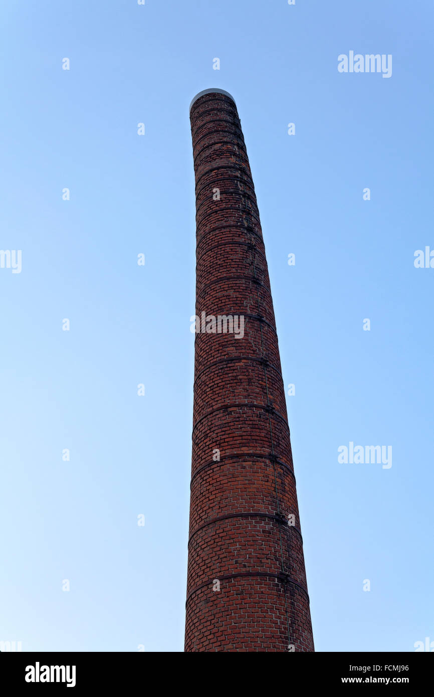 Old brick smokestack at an abandoned dairy plant. The pipe being curved and leaning slightly over, has since been demolished Stock Photo