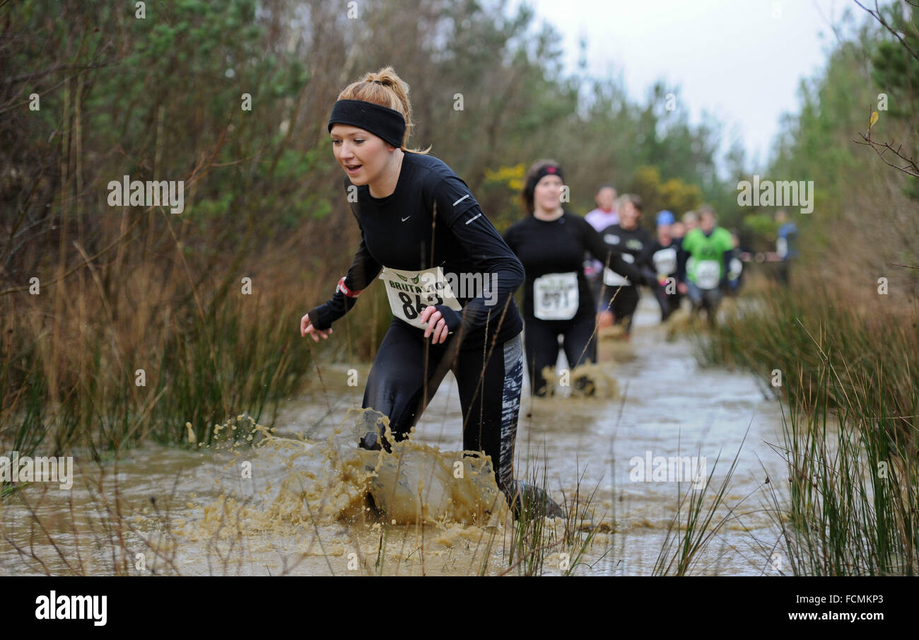 Aldershot, Hants, UK. 23rd January, 2016.  Participants makes there way through the flooded streams of the Brutal women only  10km  race at Long valley Aldershot Hampshire having to break the ice as the make there way around the course .  The recent weather made the Brutal 10km off road course live up to its name as the puddles and streams where up to waste height in many places with early runners having to break the ice as they entered the water.  Credit:  PBWPIX/Alamy Live News Stock Photo