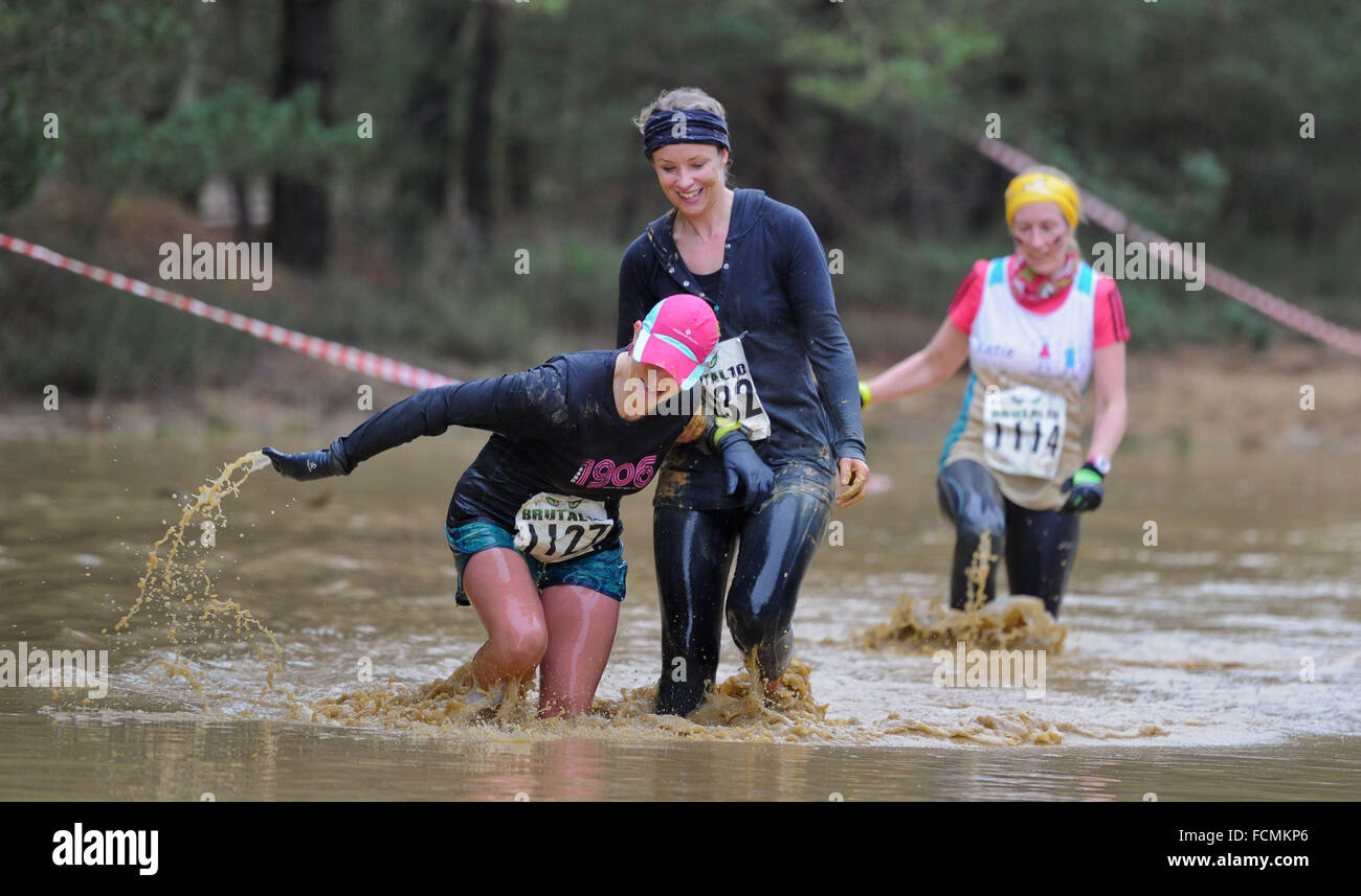 Aldershot, Hants, UK. 23rd January, 2016.  Participants  help each other out as they make there way through the flooded streams of the Brutal women only  10km  race at Long valley Aldershot Hampshire having to break the ice as the make there way around the course .  The recent weather made the Brutal 10km off road course live up to its name as the puddles and streams where up to waste height in many places with early runners having to break the ice as they entered the water. Credit:  PBWPIX/Alamy Live News Stock Photo