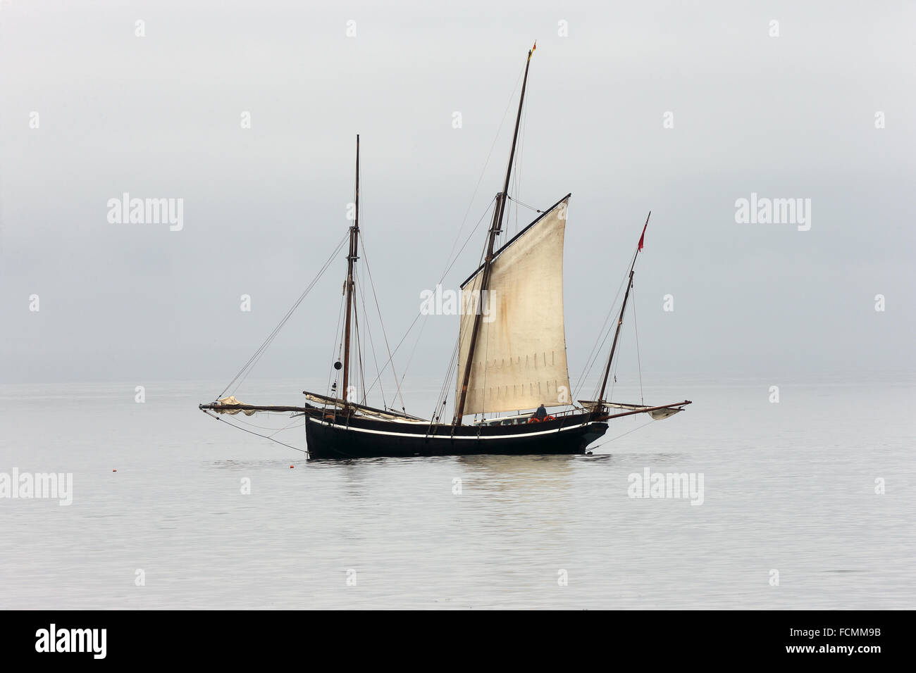 Ancient fishing boat, a Cornish lugger, becalmed off Newlyn, Cornwall, England, UK. Stock Photo