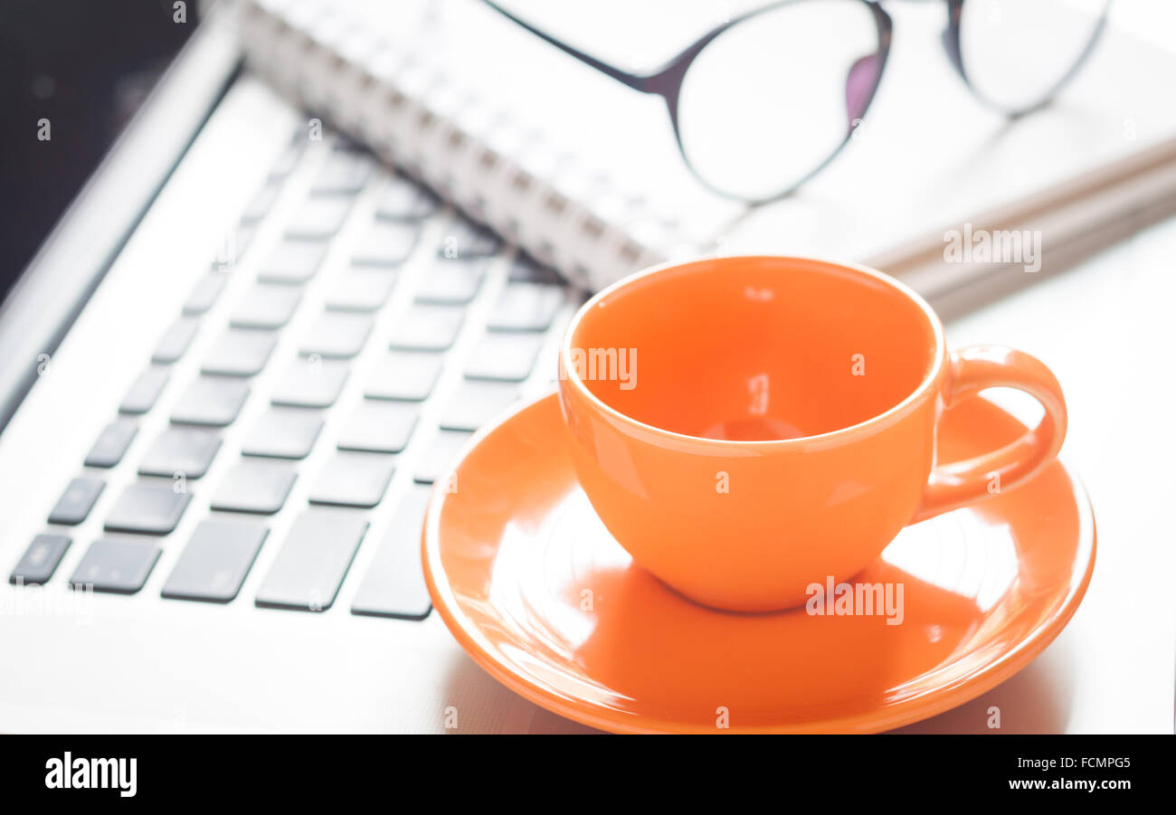 Laptop with coffee cup and notepad on desk, stock photo Stock Photo
