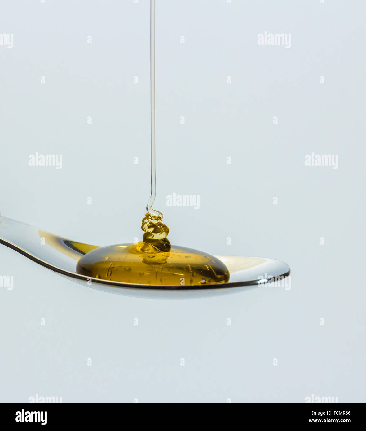 Liquid honey poured onto a teaspoon Stock Photo Alamy